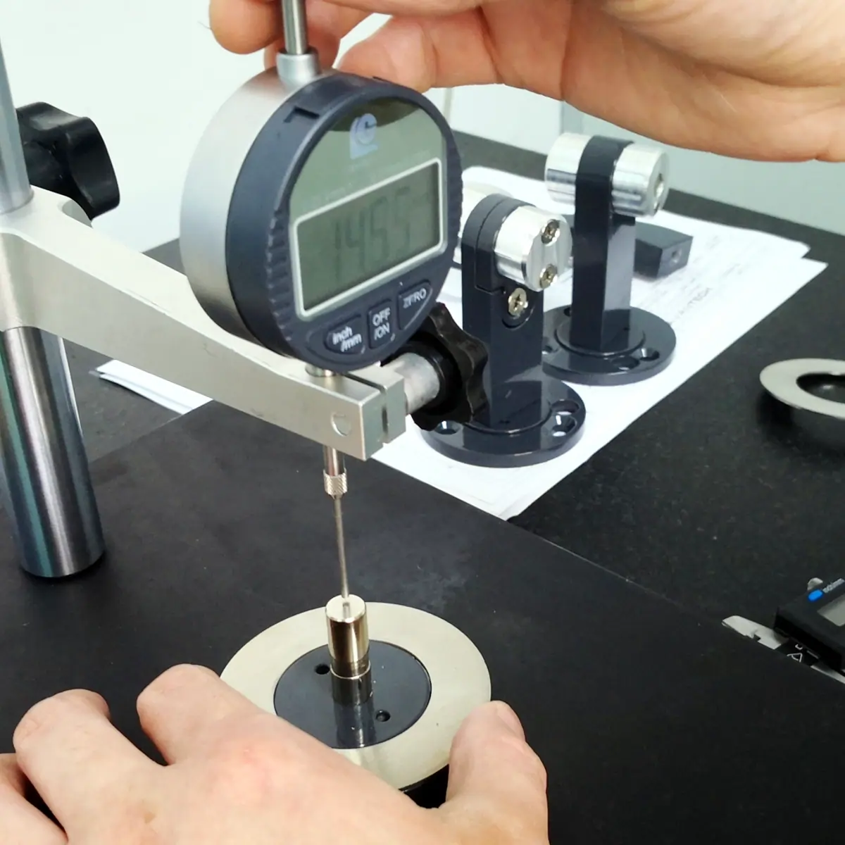 Quality inspector measuring part dimensions with a digital height gauge